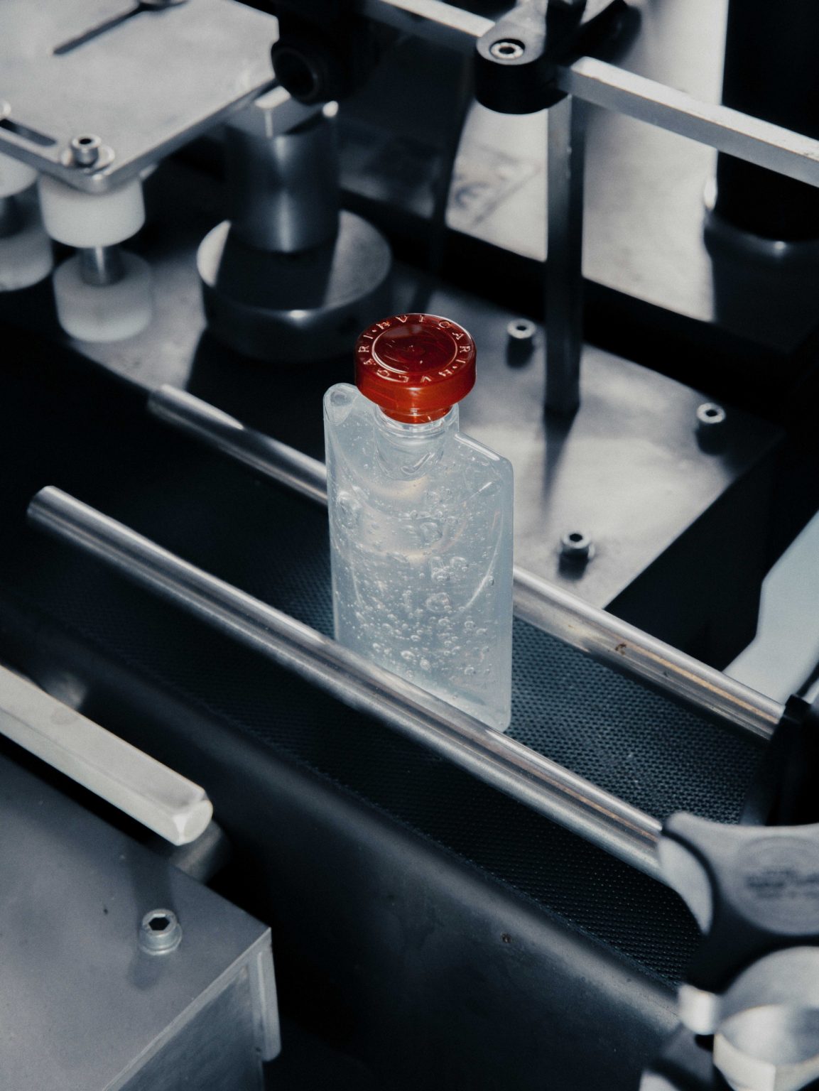 Inside ICS S.p.a. (Industrie Cosmetiche Riunite), in Lodi, Lombardy.  In this image: a bottle of Bulgari disinfectant liquid in the bottling line. Italy, April, 2020