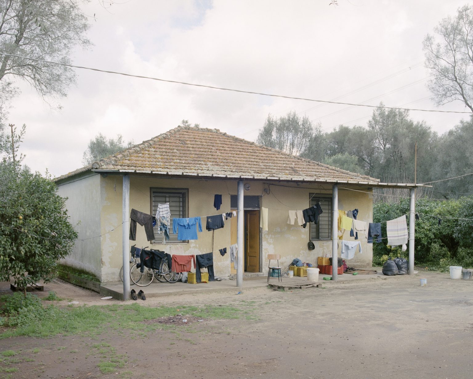 Drosi (Gioia Tauro), 2016. Temporary shelter set in a citrus grove in the plain of Gioia Tauro. According to CGIL (union organization) in Italy there are about 400 thousand foreign daily laboures who find work through the caporalato (system of directly hiring farm labour for very low wages by landowner's agents). ><
Drosi (Gioia Tauro), 2016. Rifugio temporaneo in un agrumeto della piana di Gioia Tauro. Secondo la CGIL in Italia sono circa 400 mila i lavoratori stagionali stranieri che trovano lavoro attraverso il caporalato.