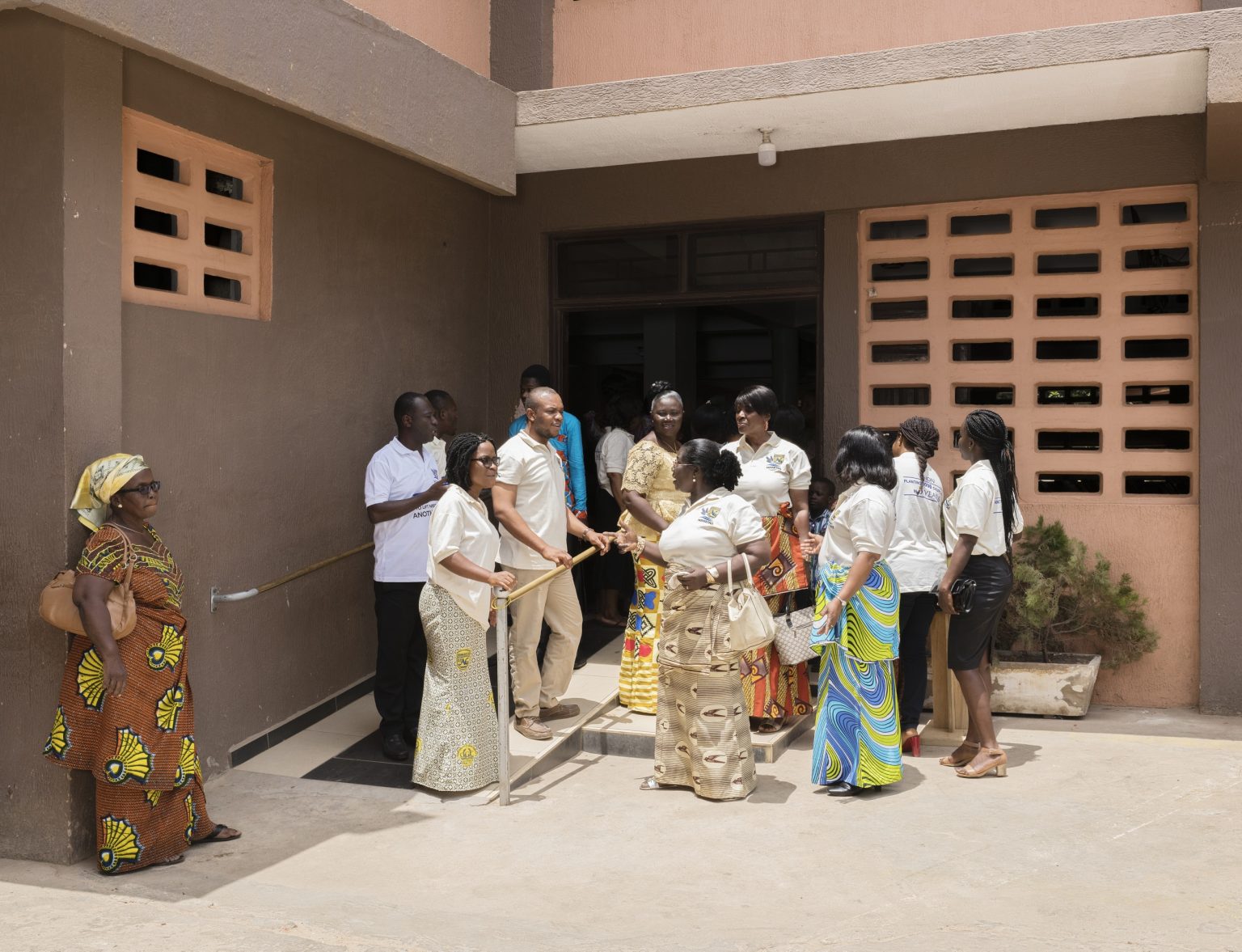 Accra, Republic of Ghana, March 2019 - Faithfuls at the entrance of the Assemblies of God's branch in North Kaneshie after the Sunday morning service. The Assemblies of God (AG), officially the World Assemblies of God Fellowship and founded in 1914 in Hot Springs, Arkansas, is a group of over 140 autonomous but loosely associated national groupings of churches which together form the world's largest Pentecostal denomination. >< Accra, Repubblica del Ghana, marzo 2019 - Fedeli all'uscita della sede di North Kaneshie della Assemblies of God dopo la messa della domenica mattina. The Assemblies of God (AG), ufficialmente World Assemblies of God Fellowship e fondato nel 1914 in Hot Springs, Arkansas, è un gruppo di oltre 140 gruppi autonomi ma liberamente associati di chiese che formano insieme la più grande denominazione pentecostale del mondo.