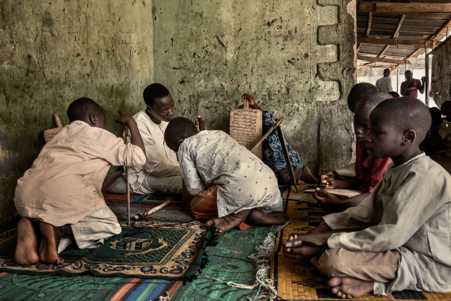Maiduguri, Nigeria, Africa, May 2021 - Baba Buji Model Sangaya Center, Bolori Ward, is one of the main Madrasa (Koranic schools) in Maiduguri. Almajiranci is a system of islamic education performed in the north of Nigeria. Colloquially, the name in its negative meaning refers to any young person that begs on the streets and doesnt attend laic school, even if in accordance with the Islamic rigour it should be forbidden for the Almajiris to beg. The almajiri system is very controversial in Nigeria, and it has been attacked for promoting child poverty and delinquency. It is estimated that in the north of Nigeria, around 8.5 million of kids attend Koranic schools. Almost 70% of unschooled kids out of the 13 million of Nigeria come from the North. ><
Maiduguri, Nigeria, Africa, maggio 2021 - Baba Buji Model Sangaya Center, Bolori Ward, è una delle principali Madrasa (scuola coranica) di Maiduguri. Almajiranci è un sistema di educazione islamica praticato nel nord della Nigeria. Colloquialmente, il termine nella sua accezione negativa, si riferisce a qualsiasi giovane che mendica per strada e non frequenta la scuola laica, anche se in virtù del rigorismo islamico, agli almajiri è proibito mendicare. Il sistema almajiri in Nigeria è molto controverso, ed è stato attaccato per aver promosso la povertà e la delinquenza giovanile. Si conta che in nel nord della Nigeria, circa 8,5 milioni di ragazzi frequentino le scuole coraniche. Circa il 70% di bambini non scolarizzati dei 13 milioni della Nigeria, provengono dal Nord.