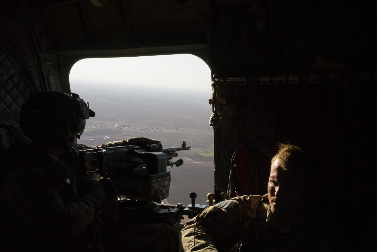 SYRIA. August 26, 2021 - A U.S. Army CH-47 Chinook helicopter gunner scans the area while transporting troops over northeastern Syria.

SIRIA. 26 agosto 2021 - Un mitragliere dell'esercito americano controlla l'area di sorvolo mentre trasporta truppe nel nord-est della Siria.