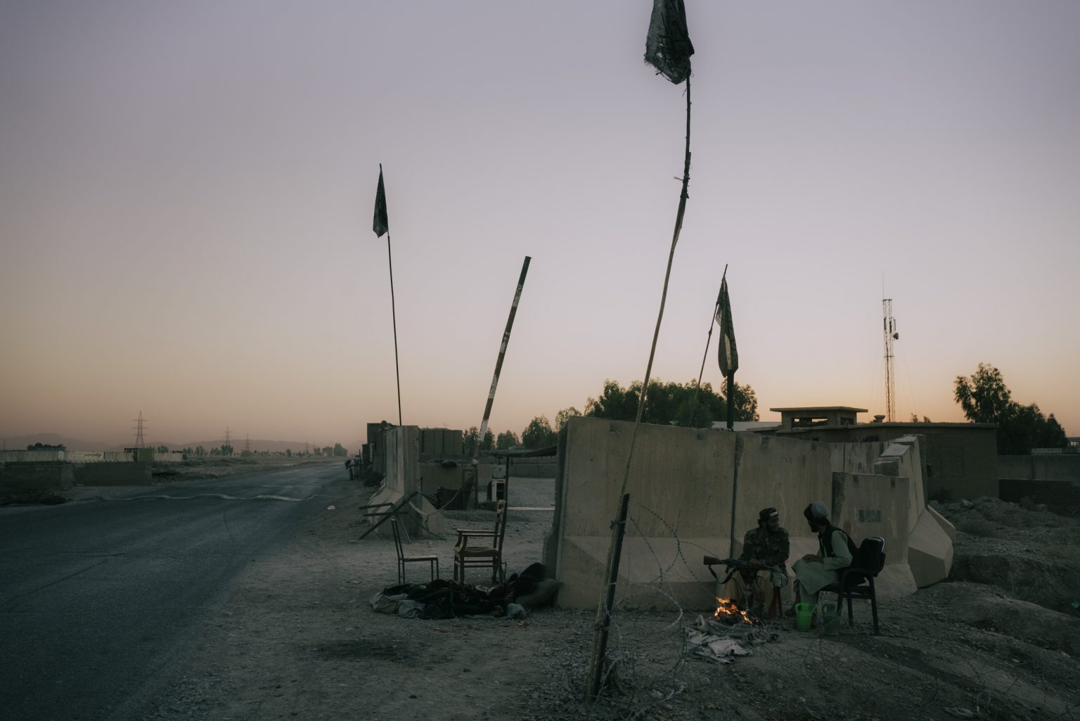 KANDAHAR, AFGHANISTAN - OCTOBER 20:
Taliban fighters warm themselves in front of a small bonfire at a checkpoint outside the city of Kandahar. They sit behind blast walls to prevent the chill wind from blowing into their bodies.
(Photo by Lorenzo Tugnoli/ The Washington Post)