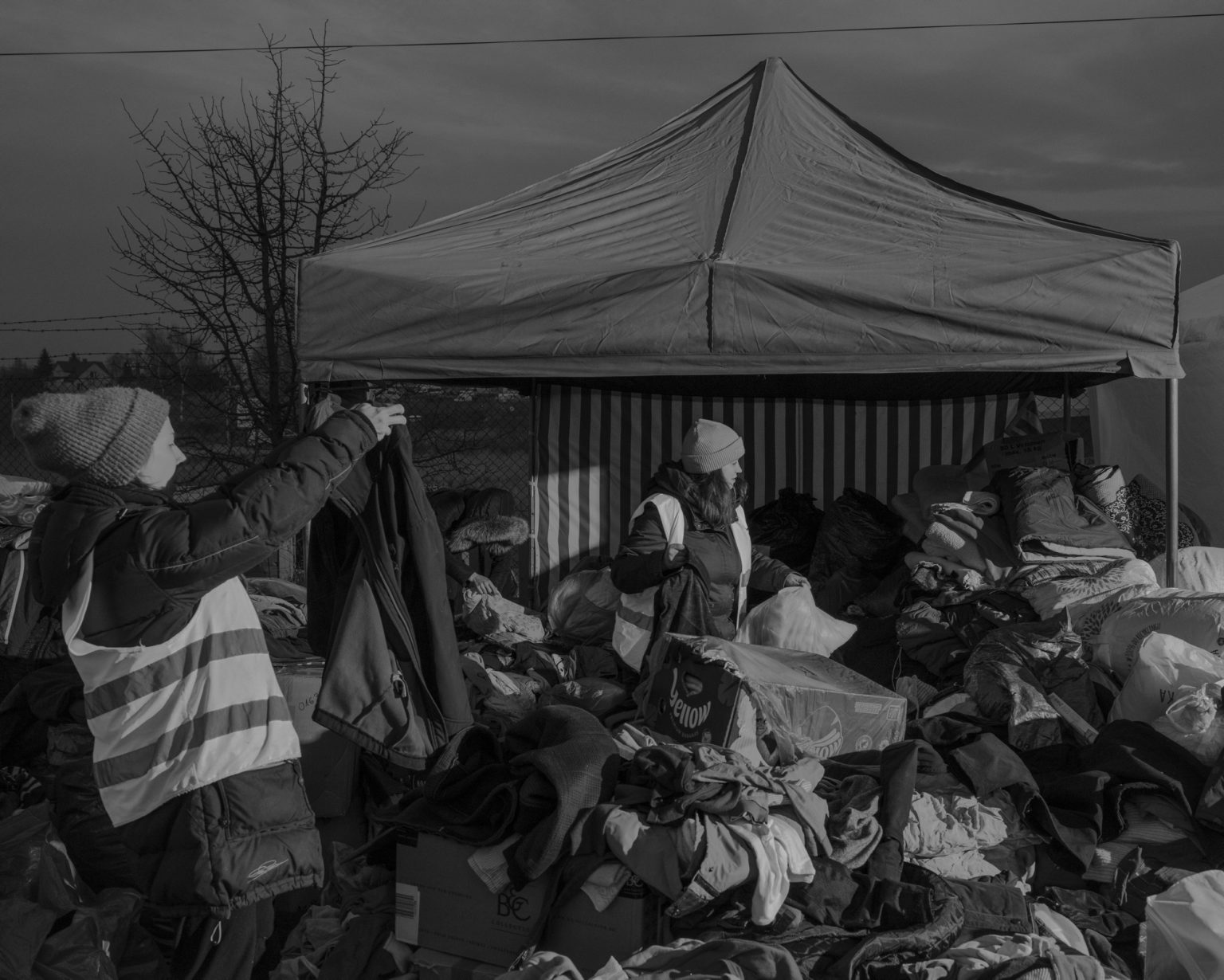 Ukrainian refugees at the Medyka border between Poland and Ukraine. More than 600,000 Ukrainians fleeing the conflict have already crossed this border making Poland the country with the largest number of refugees with one million people welcomed. Here volunteers distributing clothes. Medyka, Poland. March 2022.                                              As Russia invades Ukraine, thousands of Ukrainians are fleeing the country to find shelter in bordering countries. 
---------
Con l'invasione russa ai danni dell'Ucraina, migliaia di ucraini sono in fuga dalla nazione d'origine per cercare rifugio nelle nazioni confinanti.