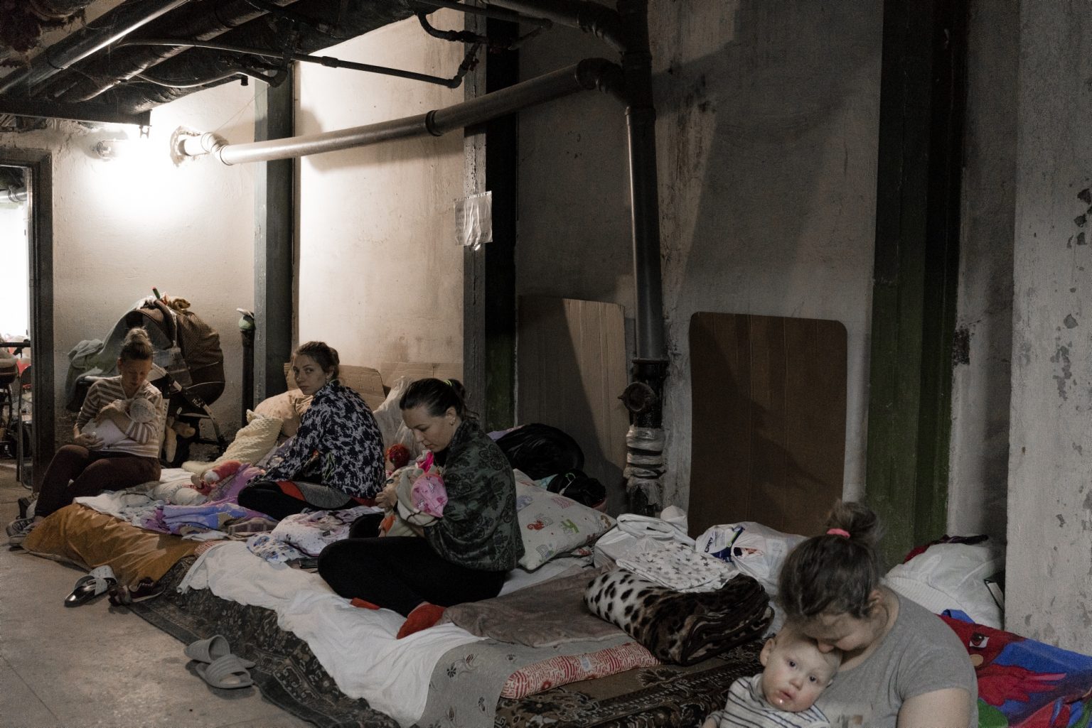 UKRAINE, Kyiv. February 28, 2022 - Women with little kids inside a basement used as a bomb shelter at the Okhmadet children's hospital in central Kyiv.
