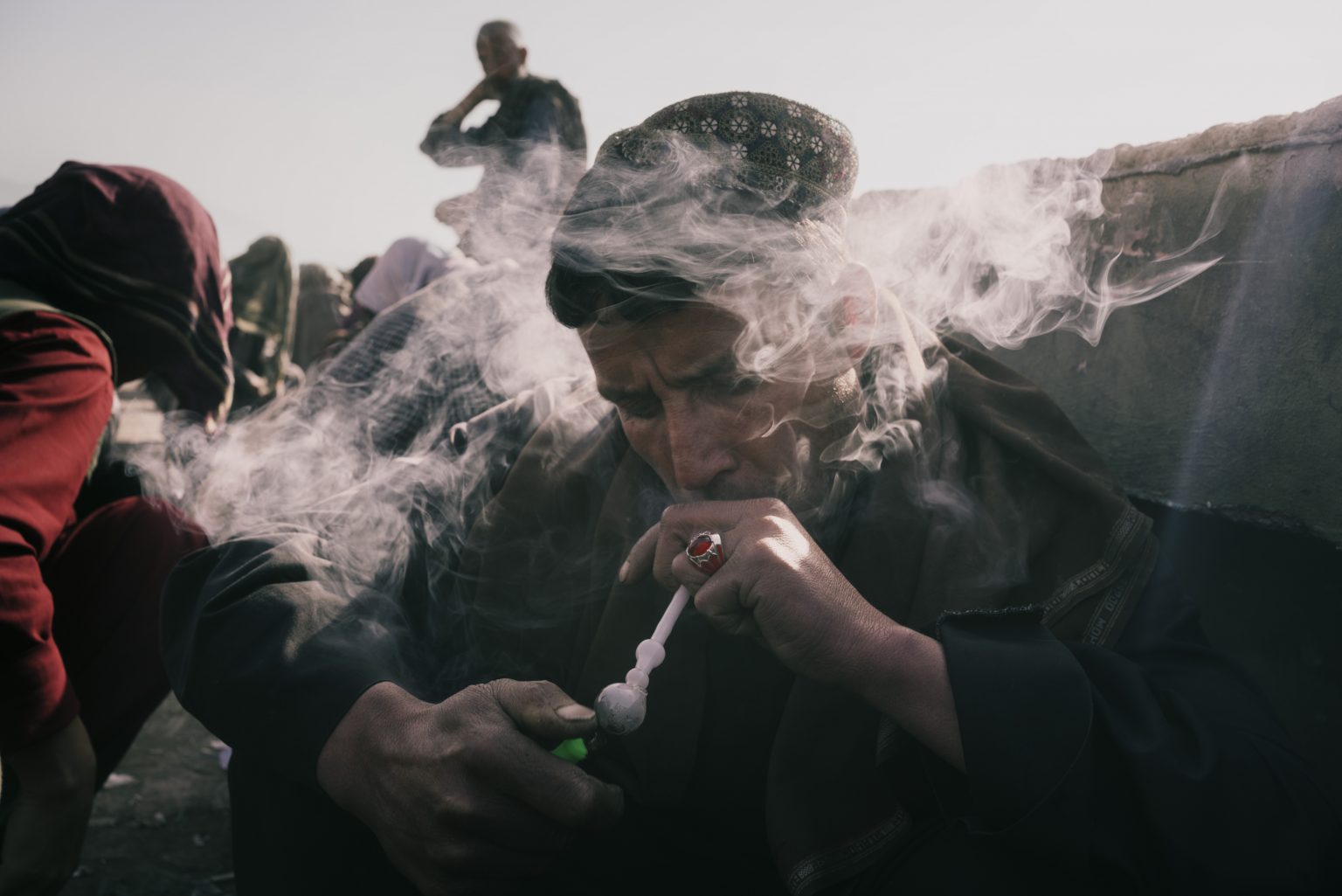 Kabul, Afghanistan, March 2022 - A drug addict smokes methamphetamine on a street. ><
Kabul, Afghanistan, marzo 2022 - Tossicodipendente fuma metamfetamina per strada.