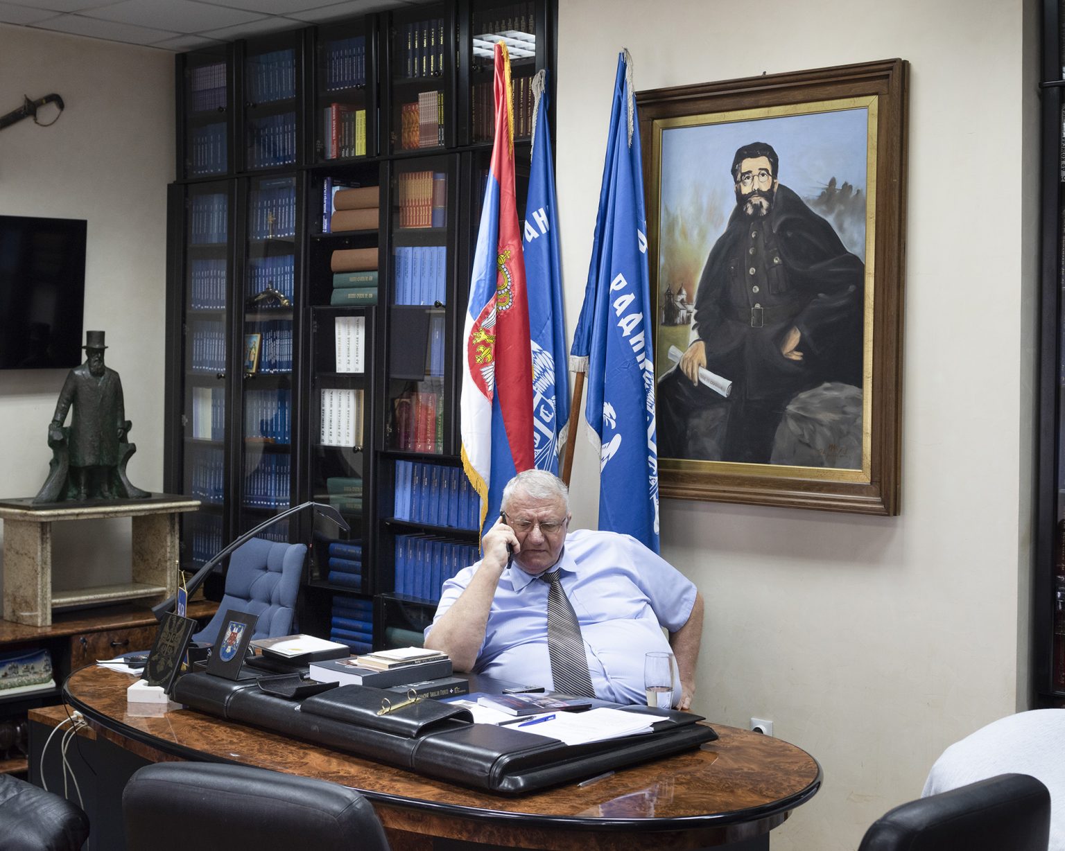 Belgrade, May 2021. Vojislav Šešelj in his office at the SRS seat in the Zemun neighborhood. Seselj is a Serbian politician, founder and president of the far-right Serbian Radical Party (SRS); he was convicted of war crimes by the International Criminal Tribunal for the former Yugoslavia (ICTY). Between 1998 and 2000, he served as the deputy prime minister of Serbia.
After spending 11 years and 9 months in detention in the United Nations Detention Unit of Scheveningen during his trial, Šešelj was permitted to temporarily return to Serbia in November 2014 to undergo cancer treatment. He led the SRS in the 2016 elections, and his party won 23 seats in the parliament. On 11 April 2018, the Appeals Chamber partially reversed the first-instance verdict, finding Šešelj guilty of crimes against humanity for his role in instigating the deportation of Croats from Hrtkovci. He was found not guilty on the remaining counts of his indictment, including all the war crimes and crimes against humanity that he was alleged to have committed in Croatia and Bosnia. Šešelj was sentenced to 10 years in prison, but because of time already spent in ICTY custody, he was not obligated to return to prison.
