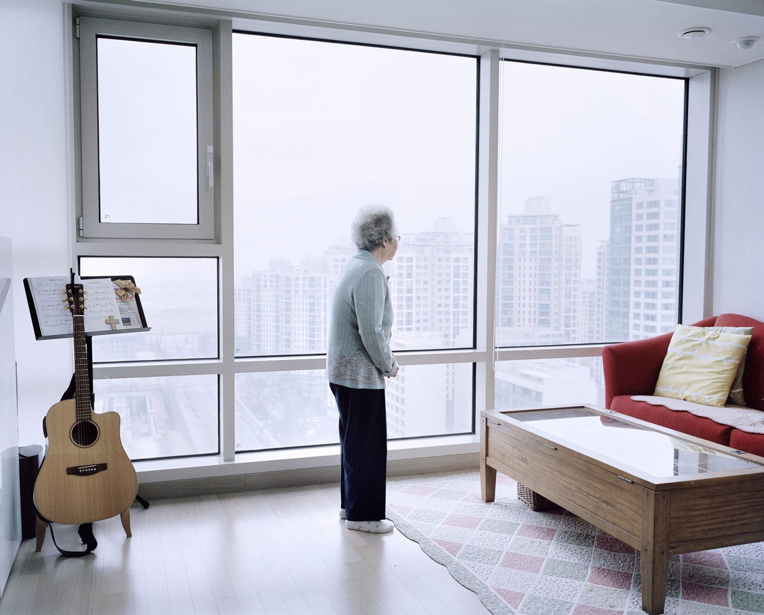Songdo International Business District, South Korea, 2015.Elderly woman looking out of the window of her new apartment, where she was moved by order of the South Korean Government. She had never step foot in a skyscraper before and spent 5 hours gazing in awe at a landscape completely new to her.