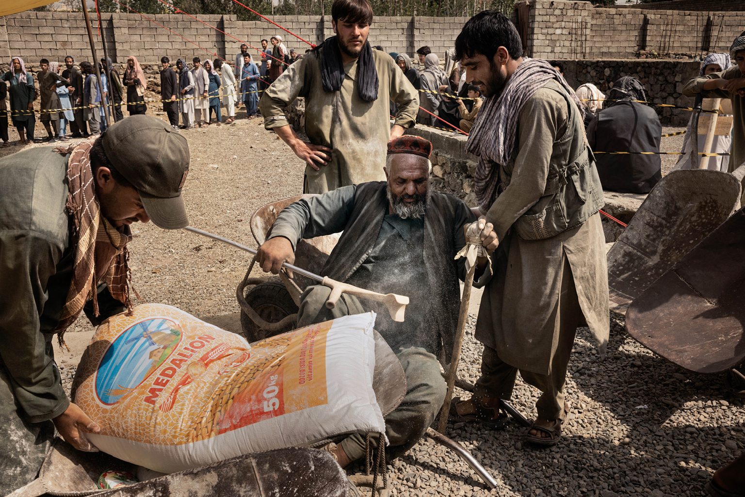 Kabul, Afghanistan, luglio 2022 - In Afghanistan oggi, secondo del stime del WFP, 19milioni di persone soffrono di acuta insicurezza alimentare, e 4 milioni tra bambini di malnutrizione. Quasi la metà dell’intera popolazione del paese dipende dagli aiuti alimentari. In ogni distretto della capitale Kabul, vengono distribuiti mensilmente 5 litri d’olio, 6kg di fagioli, 1kg di sale, 50kg di farina per nucleo famigliare. I Talebani garantiscono la sicurezza ed il controllo dell’ordine durante la distribuzione degli aiuti alimentari. ><Kabul, Afganistan, July 2022 -   Nowadays in Afghanistan, according to the WFP projections, 19 milions of people suffer from severe food insecurity, and around 4 milions children from malnourishment.Nearly half of the whole population of the country depends on food aid.In each district of capital city Kabul are handed out monthly 5 litres of oil, 6 kgs of beans, 1 kg of salt and 50 kg of flour for family unit.The Talebans ensure security and control of the order during the distribution of food aid.