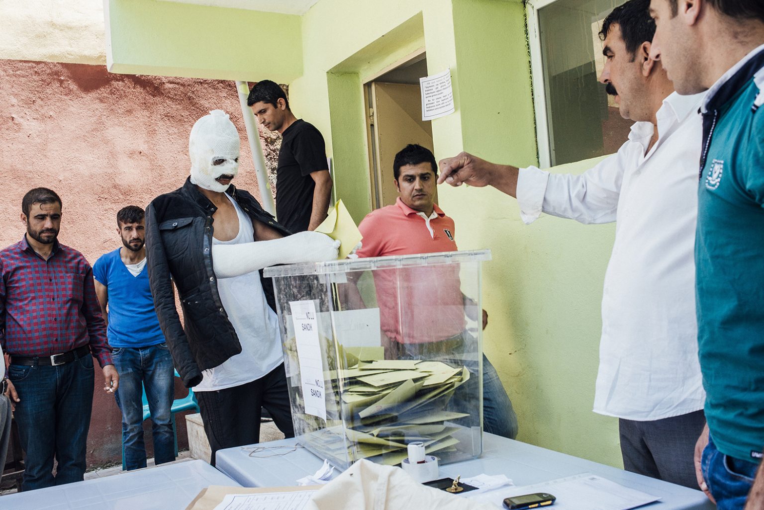 TURKEY. Diyarbakir, June 2015 – Huseyin Toprak casts his vote at a polling station, two days after he was wounded during a bomb attack on the pre-election rally of the pro-Kurdish Peoples' Democratic Party (HDP) where 4 people lost their lives.TURCHIA. Diyarbakir, June 2015 – Huseyin Toprak in un seggio elettorale, due giorni dopo un'esplosione alla manifestazione pre-elettorale del Partito Democratico dei Popoli pro-curdi (HDP) dove 4 persone hanno perso la vita.