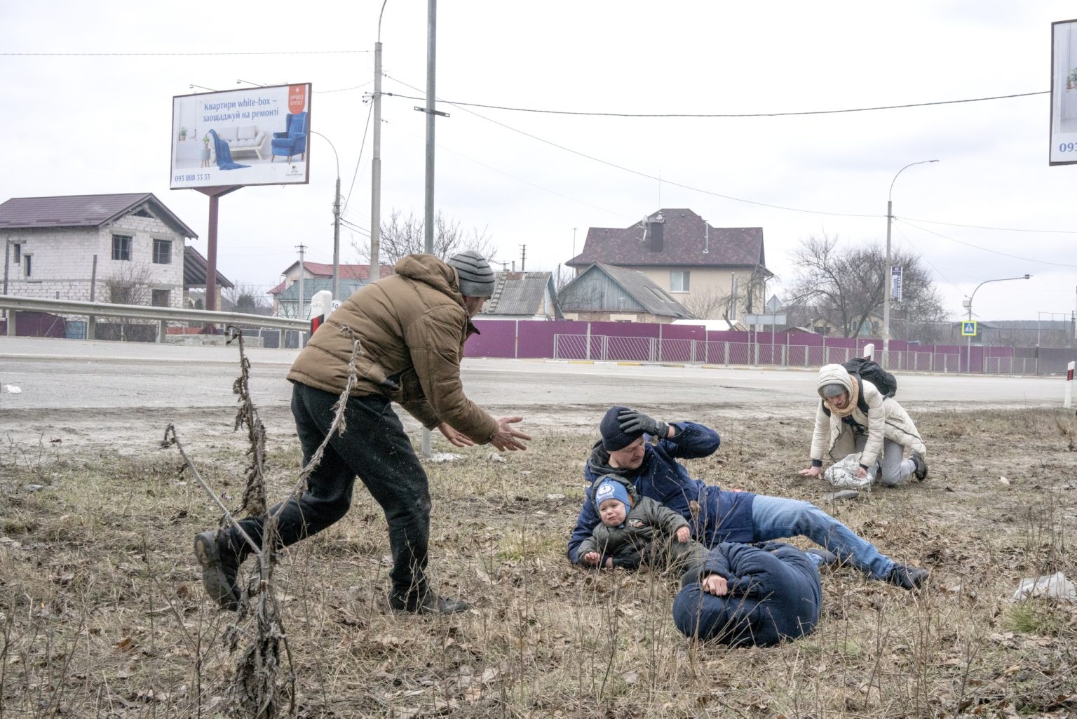 UKRAINE, Kyiv. March 06, 2022 - Civilians sprawled on the ground in search of shelter during a bombing raid after crossing a destroyed bridge as they tries to leave the city of Irpin, in the Kyiv region.