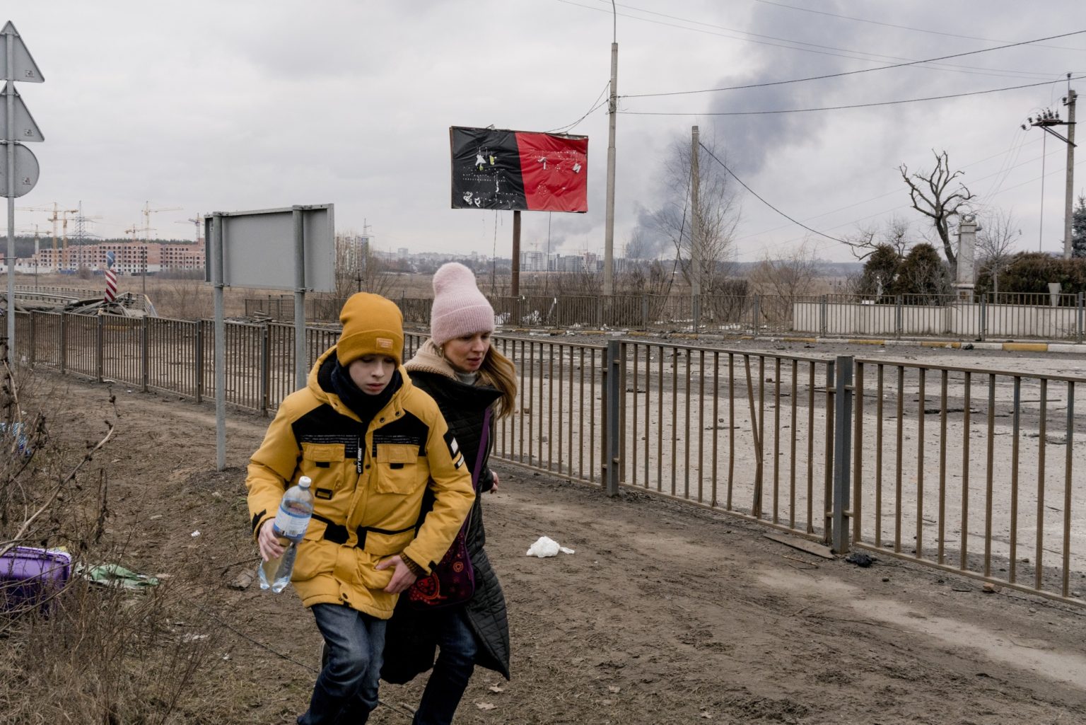 01559190 01557253 UKRAINE, Kyiv. March 06, 2022 - People run to evacuate after crossing a destroyed bridge as they tries to leave the city of Irpin during shelling, in the Kyiv region.           As Russia invades Ukraine, thousands of Ukrainians are fleeing the country to find shelter in bordering countries. 
---------
Con l'invasione russa ai danni dell'Ucraina, migliaia di ucraini sono in fuga dalla nazione d'origine per cercare rifugio nelle nazioni confinanti.*** SPECIAL   FEE   APPLIES ****** SPECIAL   FEE   APPLIES *** *** Local Caption *** 01559190