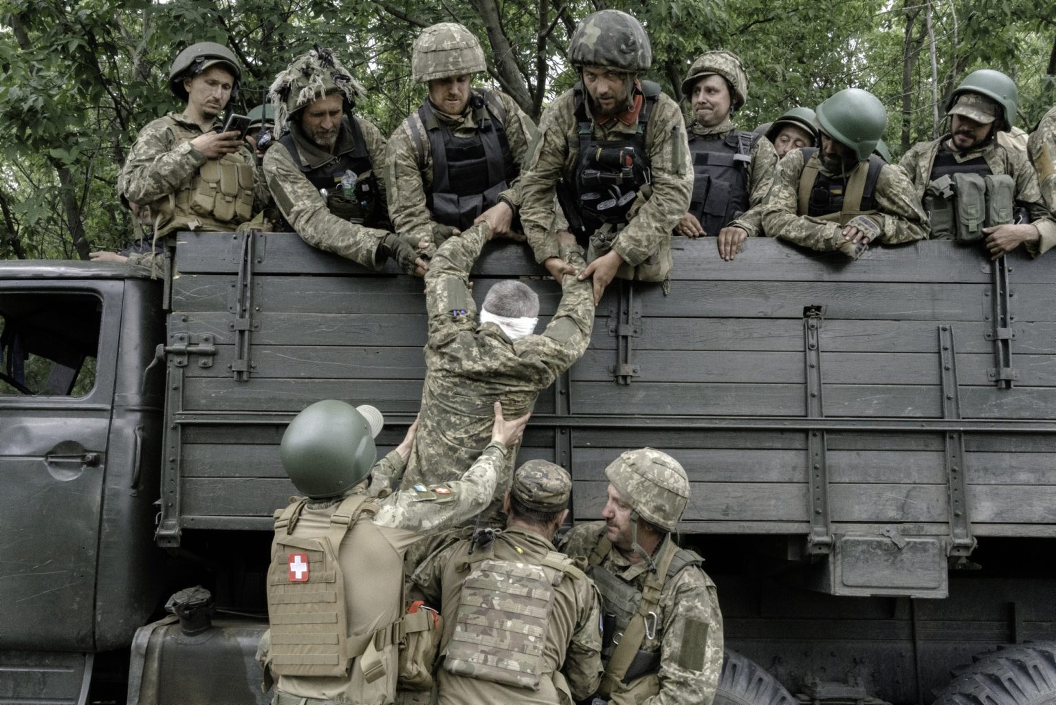 UKRAINE, Donetsk Oblast. June 22, 2022 - An injured soldier is helped to getting of from a troop carrier full of soldiers on the way back from the frontline at Severodonetsk.