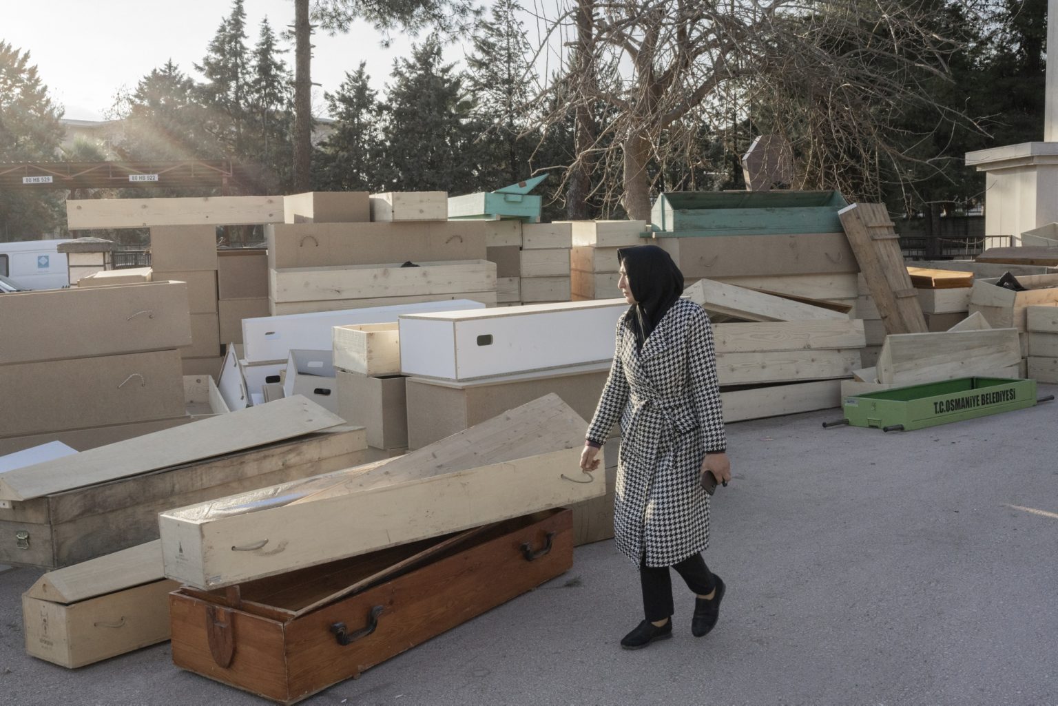 Osmaniye, Turkey, February 2023 - The aftermath of the earthquake that hit southern Turkey and northern Syria.    A woman walks in front of the coffins piled up at the entrance to Osmaniye Cemetery. ><
Osmaniye, Turchia, febbraio 2023  Le conseguenze del terremoto che ha colpito la Turchia del Sud e la Siria del nord.
