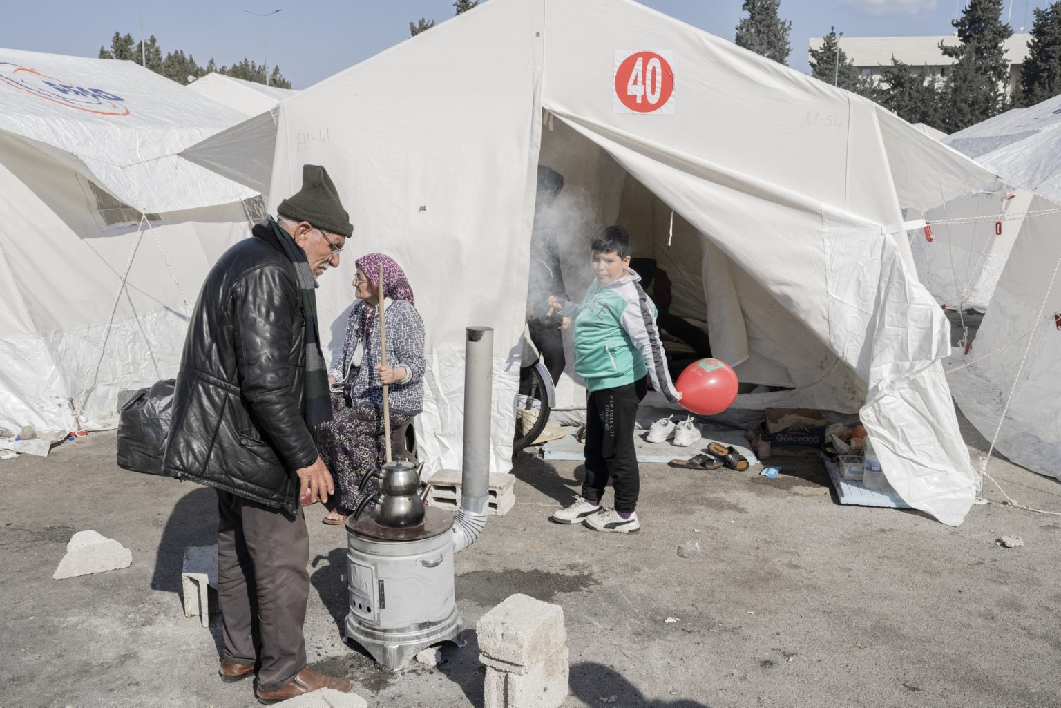 Osmaniye, Turkey, February 2023 - The aftermath of the earthquake that hit southern Turkey and northern Syria.    People stand outside a tent in one of the tent camps set up in the city.><
Osmaniye, Turchia, febbraio 2023  Le conseguenze del terremoto che ha colpito la Turchia del Sud e la Siria del nord.