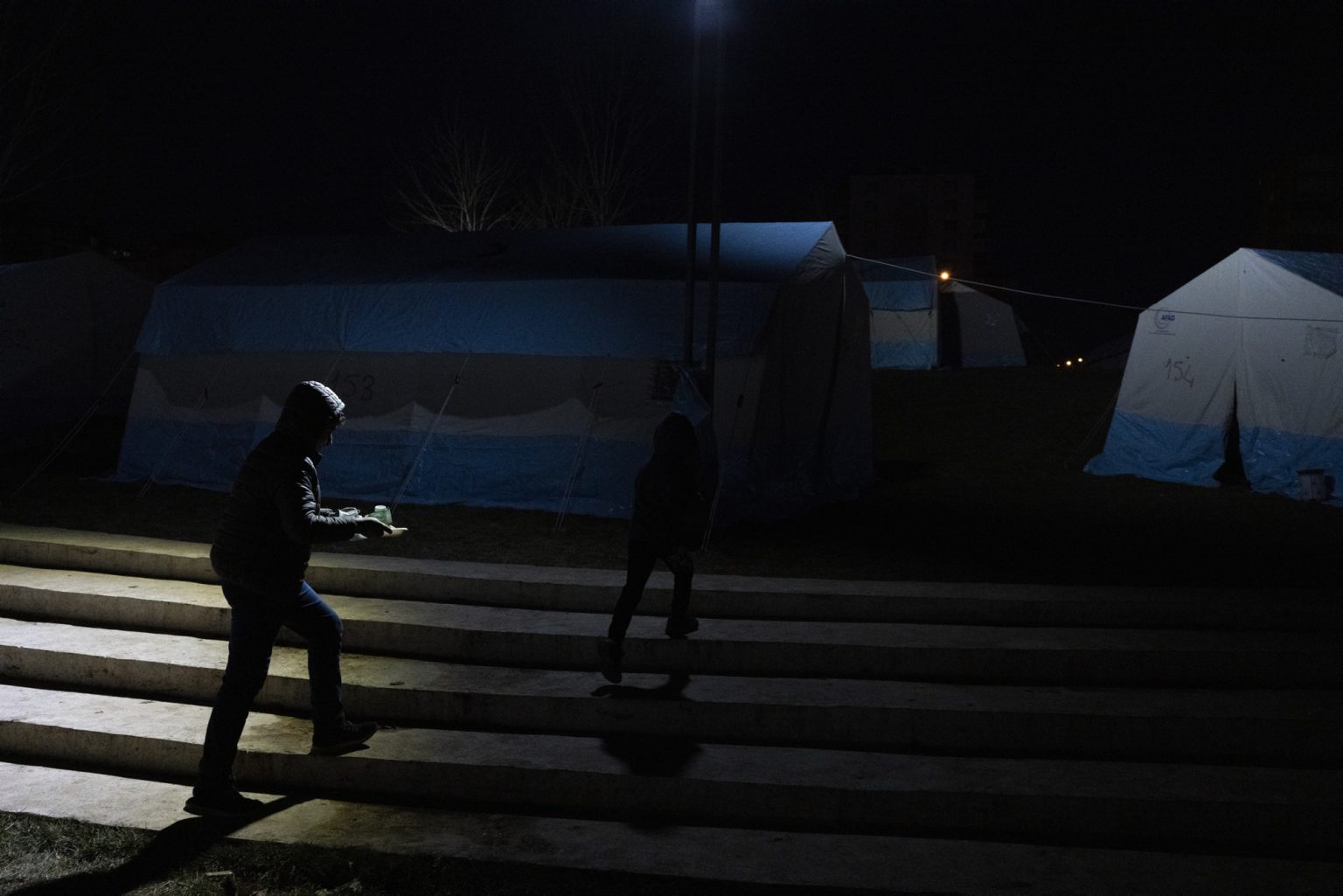 Diyarbakir, Turkey, February 2023 - The aftermath of the earthquake that hit southern Turkey and northern Syria.  A man walks inside a tent camp set up in the city of Diyarbakir. ><
Diyarbakir, Turchia, febbraio 2023  Le conseguenze del terremoto che ha colpito la Turchia del Sud e la Siria del nord.