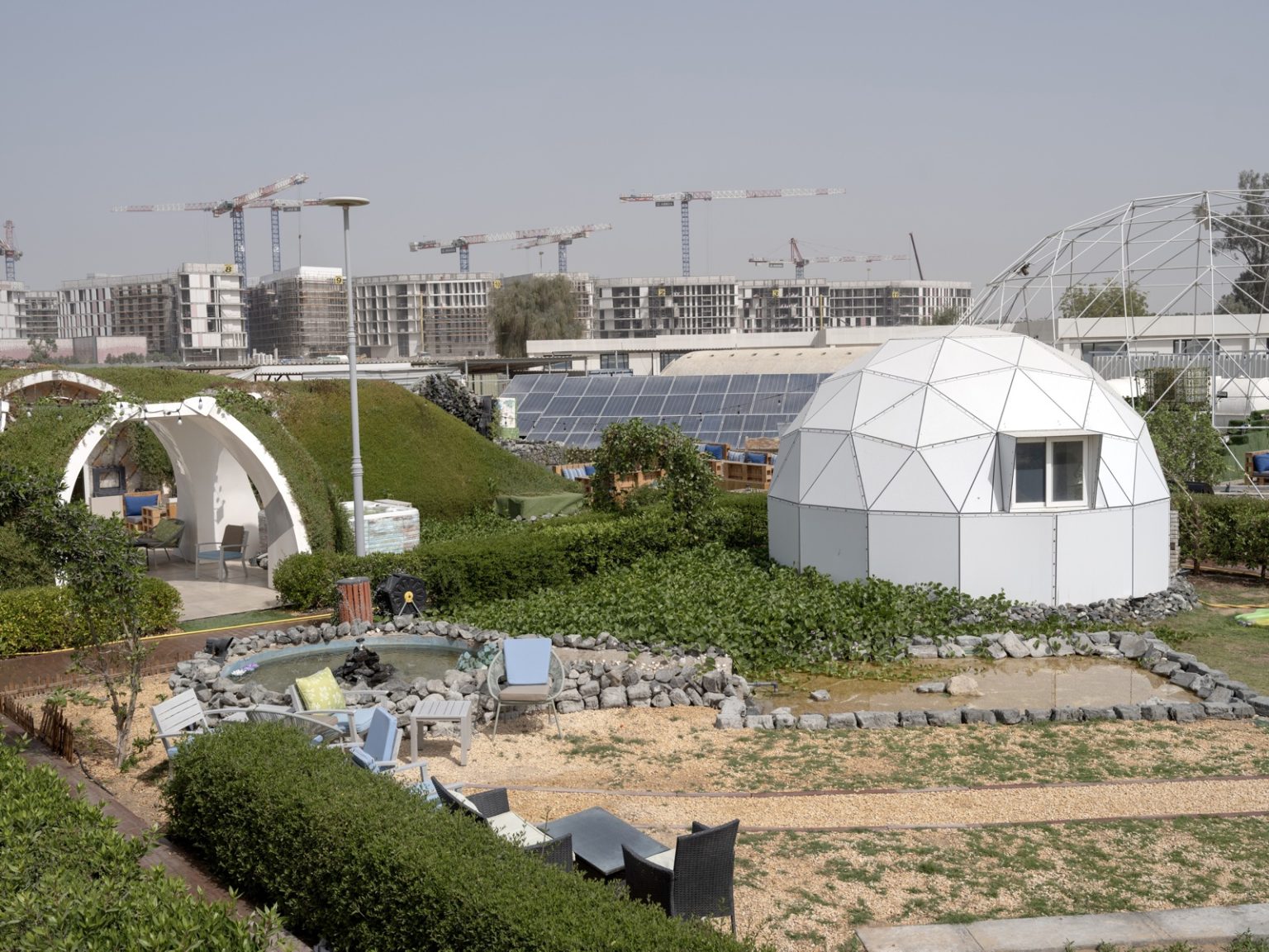 UAE, Green Dunes, 2022.
The Sharjah Research Technology and Innovation park is an ideas factory. Their CEO, Hussain Al Mahmoudi, has highlighted food security for UAE as one of the core motivations behind such ideas. In the centres sandy grounds. researchers have designed a huddle of indoor farms that can grow lettuce, vegetables and fruit. 

Made from a composite material that keeps out the blistering heat, the dome structures have the look of farming on Mars. This technology has been sold to other vertical farms in UAE. 


Emirati Arabi Uniti, Dune verdi, 2022.
Il parco di ricerca, tecnologia e innovazione di Sharjah è una fabbrica di idee. Il suo amministratore delegato, Hussain Al Mahmoudi, ha sottolineato che la sicurezza alimentare degli Emirati Arabi Uniti è una delle motivazioni principali alla base di queste idee. Nel terreno sabbioso del centro, i ricercatori hanno progettato un gruppo di fattorie al coperto in grado di coltivare lattuga, verdure e frutta. 

Realizzate con un materiale composito che tiene lontano il caldo torrido, le strutture a cupola hanno l'aspetto di un'agricoltura su Marte. Questa tecnologia è stata venduta ad altre fattorie verticali negli Emirati Arabi Uniti.